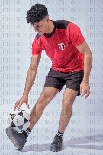 Egyptian young man wearing Egyptian national jersey and playing with the football