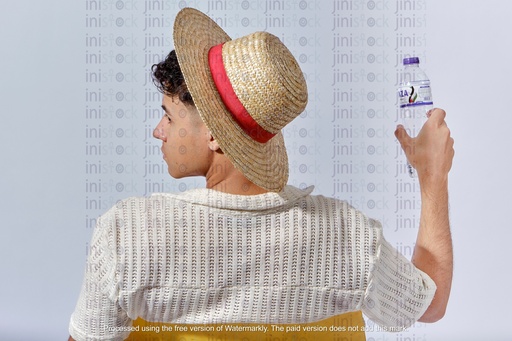 شاب مصري يحمل زجاجة ماء على الشاطئ وظهره للكاميرا