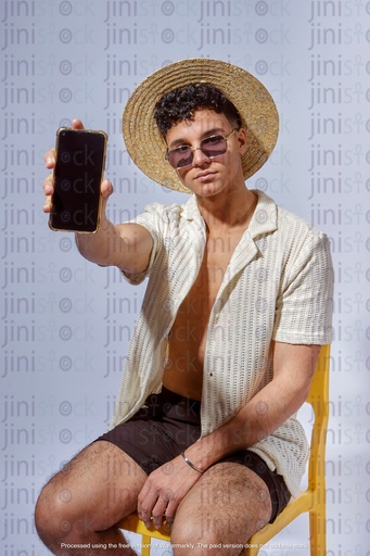 young egyptian man holding mobile while wearing a hat and sun glass in summer outfit