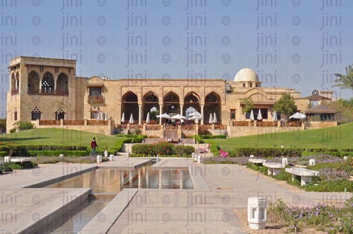 مبنى معمارى على الطراز الاسلامى فى حديقة ، بينما يوجد ممرا فى منتصف المساحات الخضراء لمرور الناس وبه مقاعد كاماكن للاستراحه يمكن  استخدام الصوره كخلفية للتصميمات التى تعبر عن هذا المعنى 