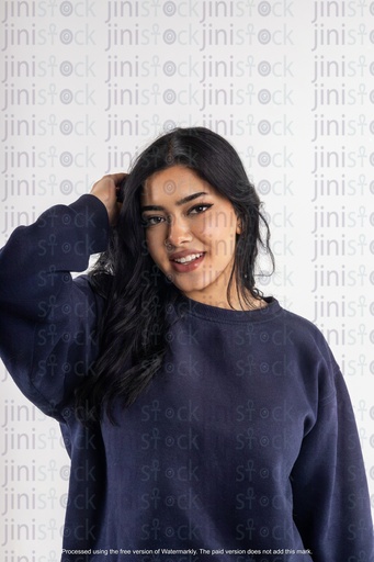 صورة فوتوغرافية لامرأة عربية تضع يديها في شعرها الجميل على خلفية معزولة