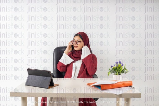 working saudi khaliji woman from gulf on talking on the phone behind her desk office