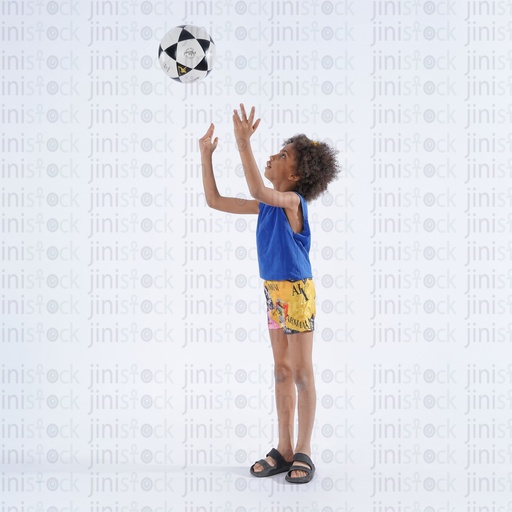 Egyptian boy with curly hair playing with football
