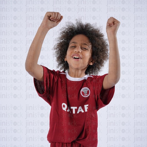 happy khaliji qatary little boy wear qatar national team shirt and cheering el enab