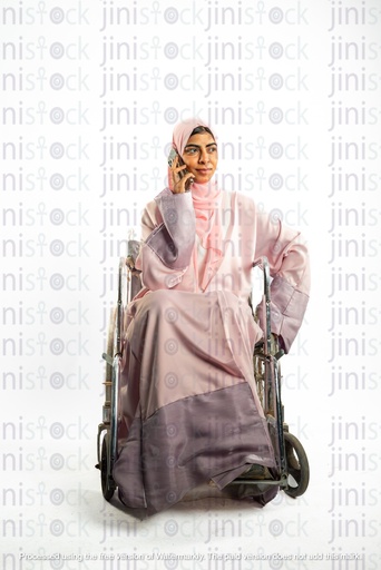 امرأة خليجية سعودية من الخليج على كرسي متحرك تتحدث على الهاتف