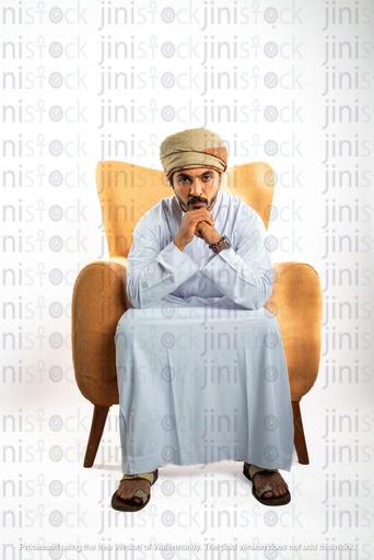 عماني من عمان رجل خليجي من الخليج يجلس على كرسي وينظر إلى الكاميرا