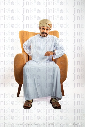 عماني من عمان رجل خليجي من الخليج يجلس على كرسي ويعاني من آلام أسفل الظهر