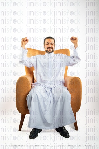 رجل سعودي خليجي سعيد يهتف وهو جالس على كرسي