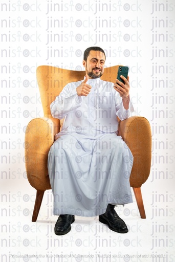 saudi khaliji man from gulf sitting on a chair holding mobile phone and making a thumb up