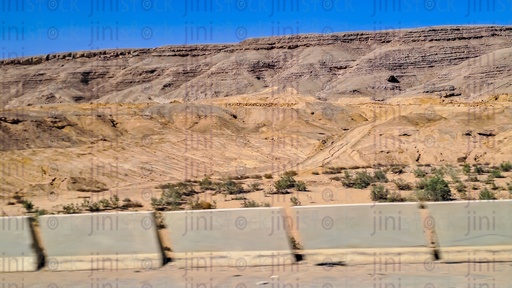 Mountains and plants in the desert on a traveling road in Egypt as a designs background