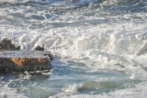 A beach, water splash, rock and waves in Alexandria- Alexandria Corniche beach at sunset.