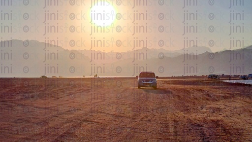 جبال ضبابية ومنطقة رمال عند غروب الشمس على شاطئ دهب جنوب سيناء