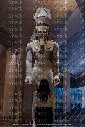 بنت مصرية تقف امام تمثال رمسيس الثانى داخل متحف مصري