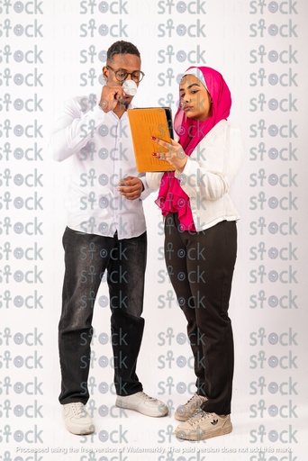 A veiled Nubian girl standing holding an orange file with a Nubian young man drinking coffee