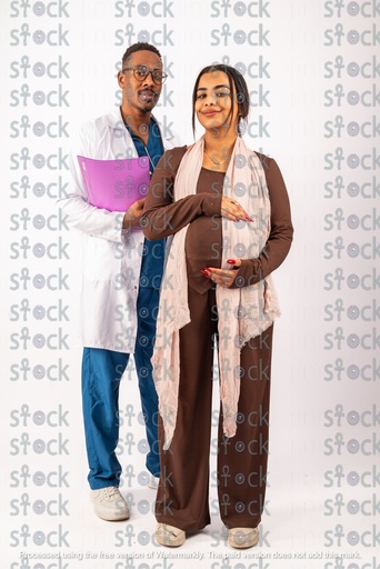 The doctor is holding a file and the mother is putting her hand on her pregnant belly