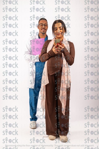 الام تنظر الى هاتفها والطبيب يحمل ملف