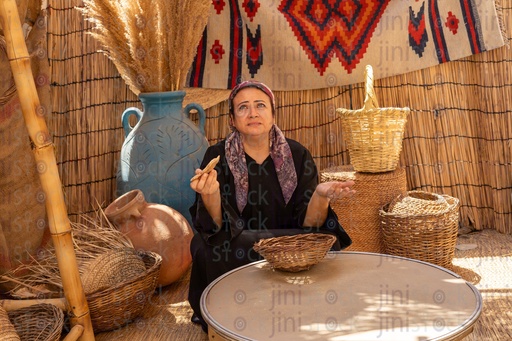 A woman sitting in a wicker hut