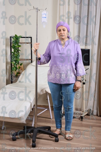 Sick woman standing with a cannula in her hand