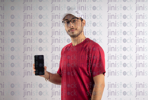 man with white hat and eye glass holding a mobile- stock image